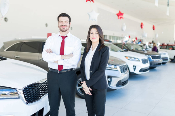 Portrait of Hispanic dealers wearing formals while working in car showroom - Fotografie, Obrázek