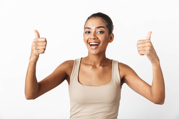 Beautiful young african woman casually dressed standing isolated over white background, showing thumbs up - Foto, Imagem
