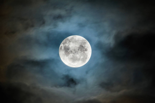 The full moon peeking through a break in the clouds. Photographed in the Southern Hemisphere - Photo, Image