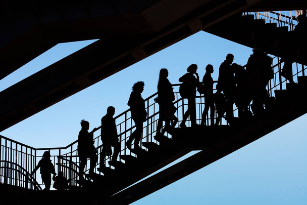 Силуэты людей на лестнице против неба
 - Фото, изображение