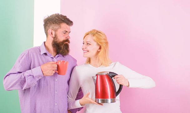 Spending good morning together. Couple prepare morning drink electric kettle device. Electric kettle boils water very quickly. Prepare favourite drink in minutes. Modern devices make our life easier - Fotó, kép