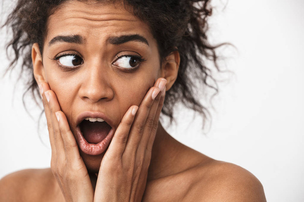 Close up of a beautiful shocked young topless african woman posing over white background - Zdjęcie, obraz