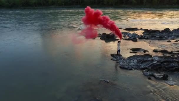 Mujer excursionista vista aérea con bomba de humo en la mano
 - Imágenes, Vídeo