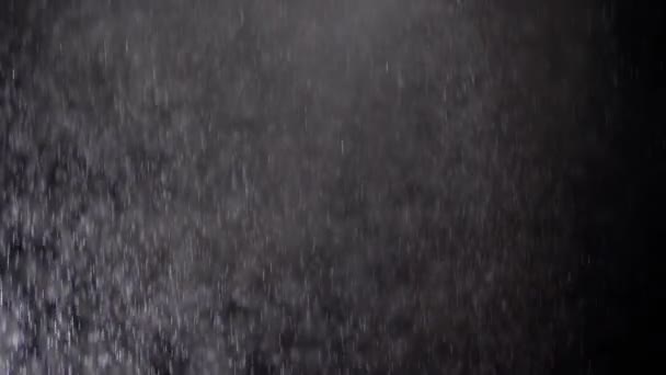 Spuitbussen spuit kleine druppels Water op een zwarte achtergrond. Slow Motion - Video