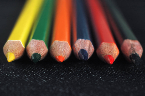 Lápis coloridos sobre um fundo de tecido escuro. Profundidade de campo rasa
 - Foto, Imagem