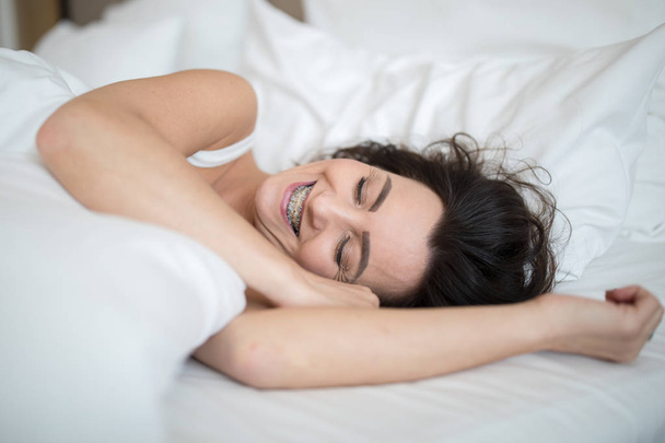 Beautiful young woman sleeping on bed at bedroom - Фото, изображение