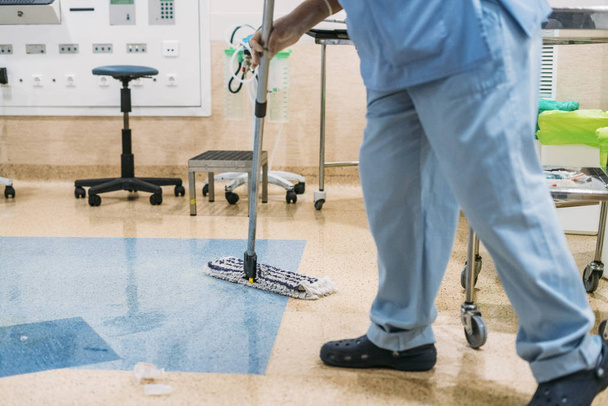 Foto de conceito de um trabalhador do hospital fazendo limpeza na sala de operação - Foto, Imagem