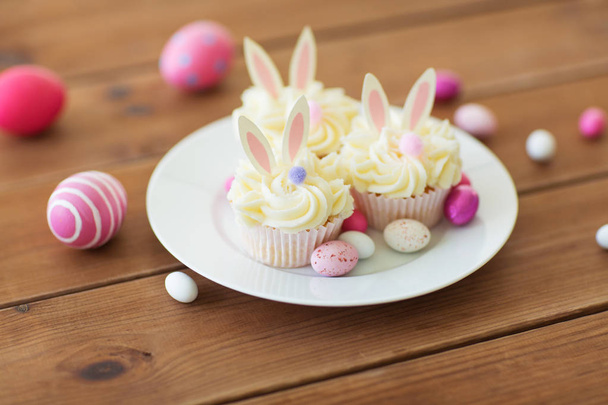 cupcakes with easter eggs and candies on table - Foto, Imagem