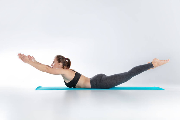 Beautiful woman doing sport exercises on mat - Photo, Image