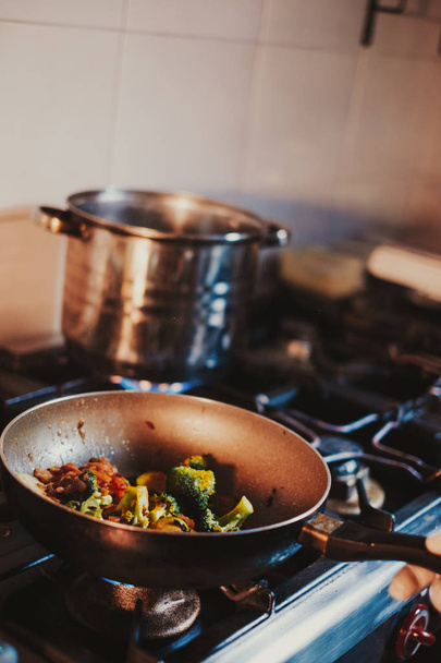 Cucina chef cottura verdure in padella sul fornello a gas
 - Foto, immagini
