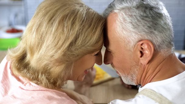 Positive retired couple nuzzling, man and woman affection, old age love, support - Zdjęcie, obraz