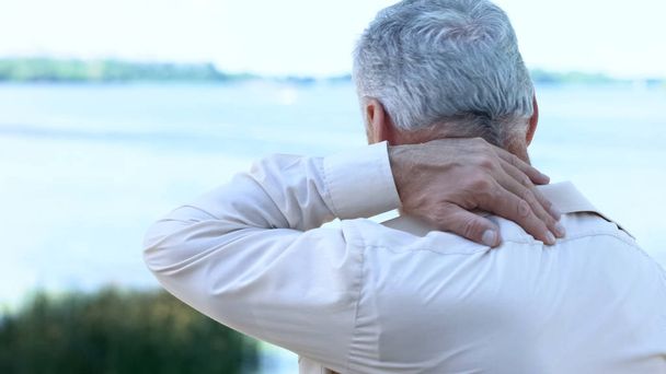 Mature man massaging neck and shoulders, aging health problem, painful injury - Φωτογραφία, εικόνα