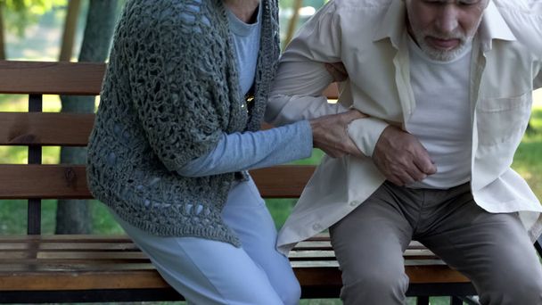 Rheumatism, senior man suffering from backache, wife helping to sit down, care - Φωτογραφία, εικόνα