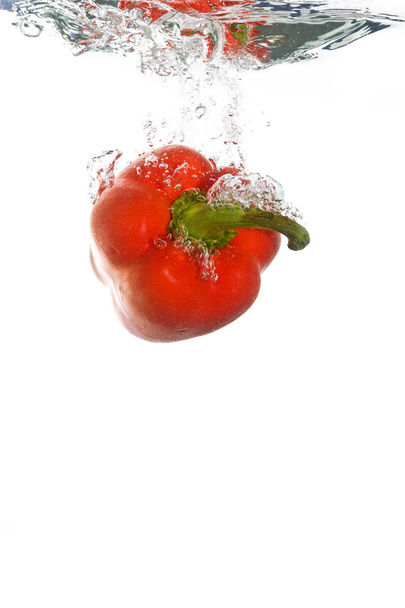 Un paprika tombant dans l'eau claire
 - Photo, image