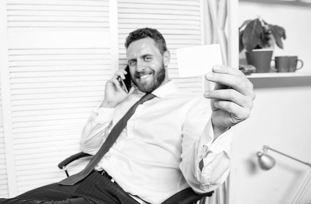 Man successful businessman phone conversation ask service. Businessman bearded guy sit office feel confident. Man hold business or bank card copy space. Here is my number. Feel free to contact me - Foto, afbeelding