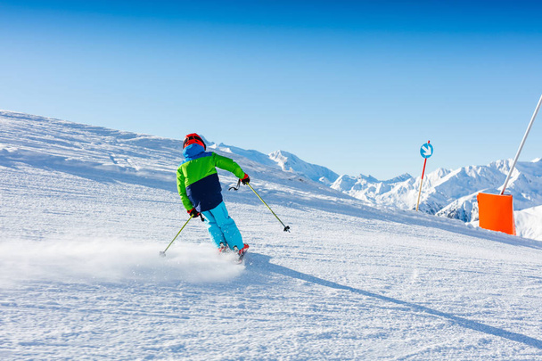Cute skier boy in a winter ski resort. - Foto, afbeelding
