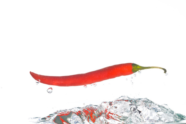 A chili pepper jumping out of the clear - Fotoğraf, Görsel