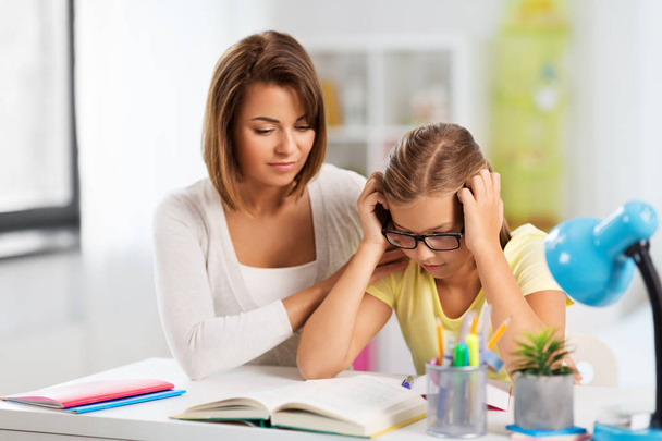 mother helping daughter with difficult homework - Фото, зображення
