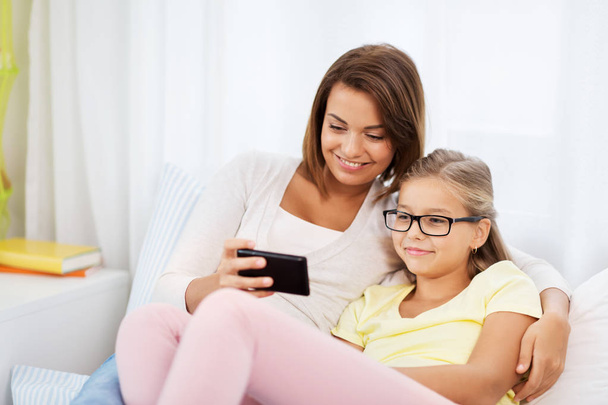 happy mother and daughter with smartphone at home - Φωτογραφία, εικόνα