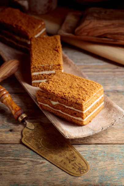 Ev yapımı katmanlı tatlım pasta krema eski ahşap bir masa üzerinde ile. - Fotoğraf, Görsel