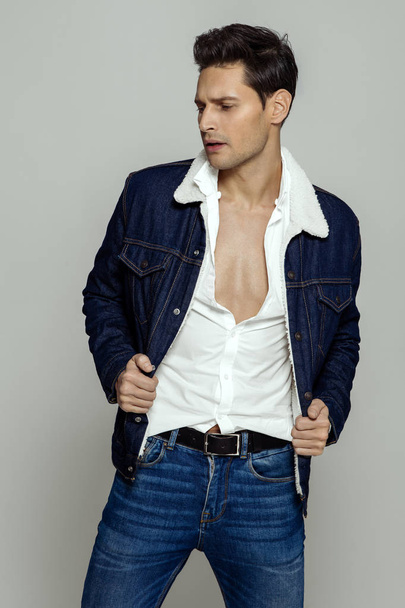 Sexy man wear white unbuttoned shirt and jeans isoalted on gray background - Foto, Bild