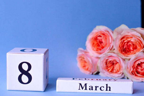 Calendario con la fecha Día de la Mujer 8 de marzo con rosas melocotón sobre fondo púrpura
. - Foto, imagen