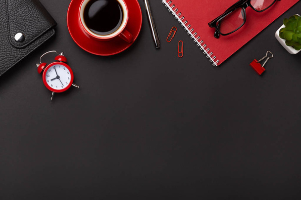 Black background red coffee cup notepad alarm clock flower diary scores keyboard on the table. Top view with copy space. - Photo, Image