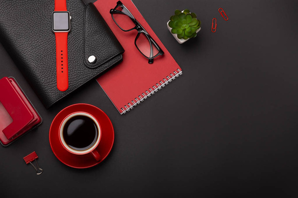 Черный фон красный кофе чашки блокнот будильник цветок дневник дневник баллы клавиатуры на столе. Вид сверху с пространством для копирования
. - Фото, изображение