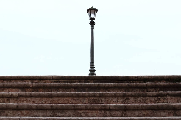Street lamp with the white background on the top of the old steps - Photo, Image