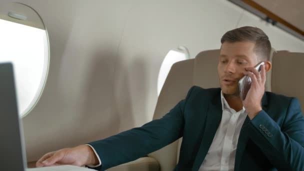 Obchodník mluví přes mobilní telefon partner připojení letadlo cestování tryskáč - Záběry, video