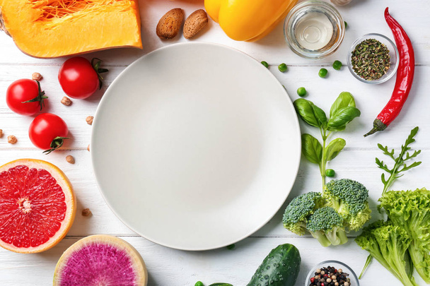 frische Zutaten für Gemüsesalat und Teller auf Holztisch. Ernährung - Foto, Bild