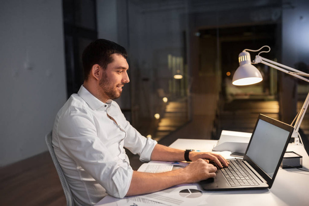 businessman with laptop working at night office - Фото, зображення