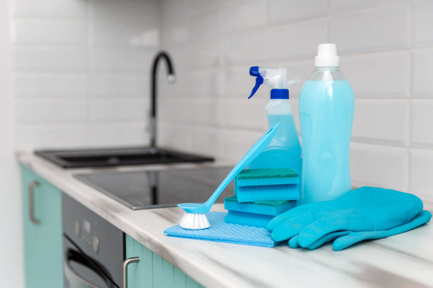 A set of blue cleaning products and tools for cleaning is on the kitchen table. - Foto, Bild