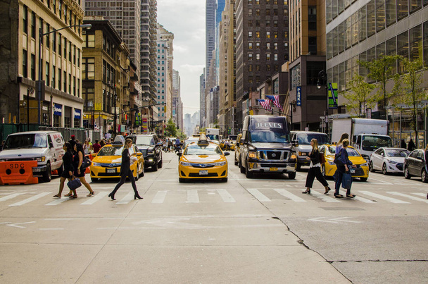 New York, USA- September 2017 Manhattan street with yellow taxi  crossing the road and people - Zdjęcie, obraz
