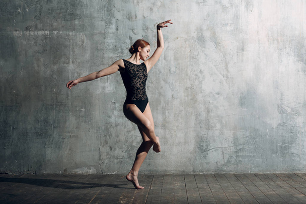 Ballerina vrouw. Mooie jongedame balletdanser, gekleed in professionele outfit, pointe-schoenen en zwart lichaam. - Foto, afbeelding