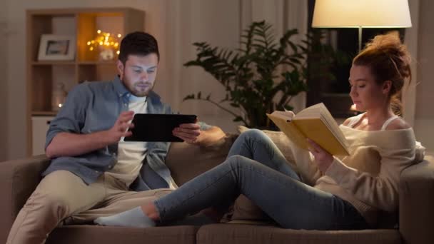 couple with tablet computer and book at home - Filmagem, Vídeo