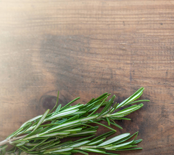 Rosemary herb bound on a wooden background with copy space. Fresh rosemary. Top view - Φωτογραφία, εικόνα