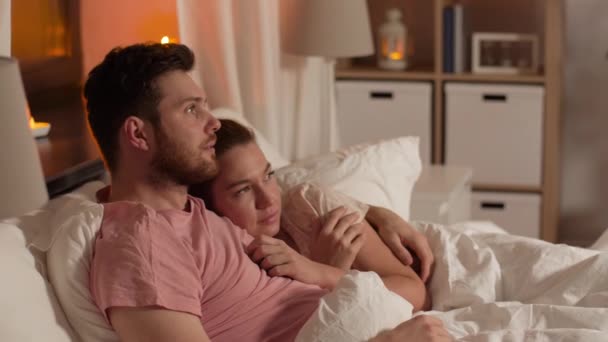 couple watching horror on tv in bed at night - Кадры, видео