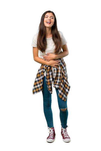 A full-length shot of a Teenager girl with shirt tied to the waist smiling a lot while putting hands on chest - Fotoğraf, Görsel