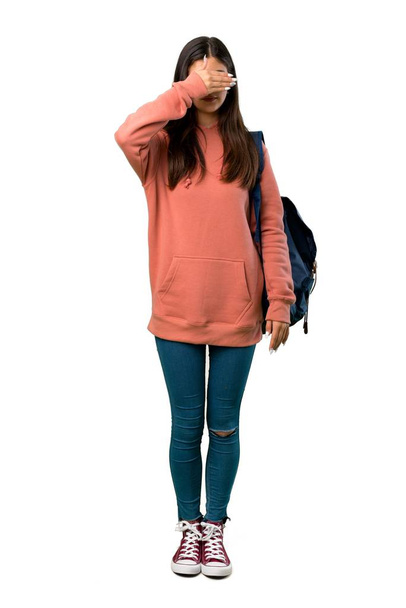 A full-length shot of a Teenager girl with sweatshirt and backpack covering eyes by hands. Do not want to see something - Foto, imagen