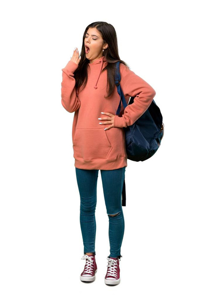 A full-length shot of a Teenager girl with sweatshirt and backpack yawning and covering wide open mouth with hand - Foto, Bild