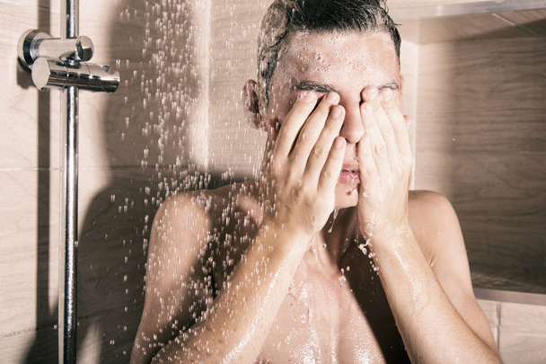 The guy is washing in the shower - 写真・画像