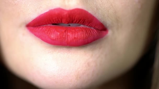 Verleidelijke lichte glimlach van het meisje close-up, rode lippenstift op de lippen, sneeuwwitte zelfs tanden besmeurd met rode lippenstift, een vrouw glimlacht - Video