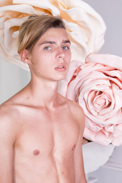 Young attractive guy.Roses on the background. Elegant face - Фото, зображення