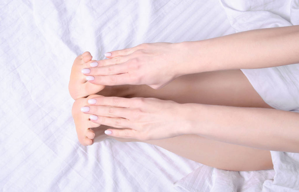 Female legs beauty on white bed physical exercise morning - Foto, Imagen