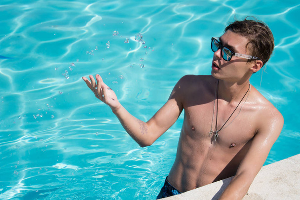 Young attractive guy. Summer, relaxation and pool. - Foto, immagini