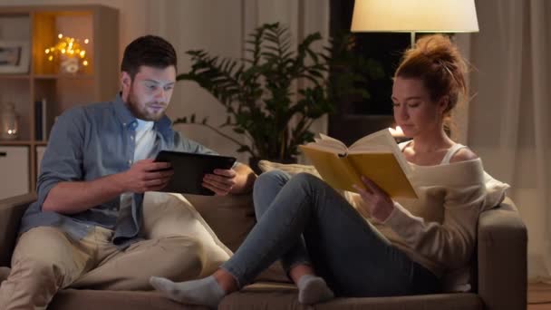 couple with tablet computer and book at home - Footage, Video