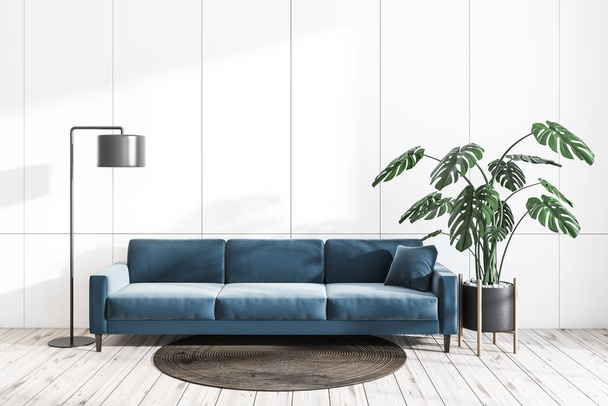 Interior of minimalistic living room with white walls, wooden floor, long blue sofa with blue cushion, round rug, stylish floor lamp and potted plant. 3d rendering - Foto, imagen