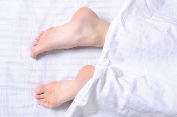 Female legs beauty on white bed beauty heels of the foot, top view - Foto, Imagen