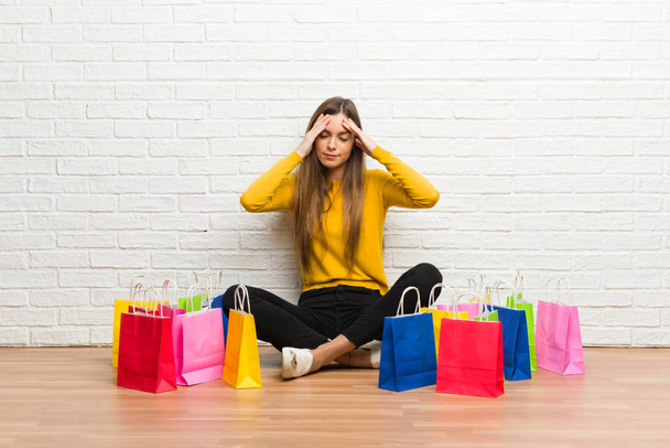 Chica joven con un montón de bolsas de compras infeliz y frustrado con algo
 - Foto, imagen